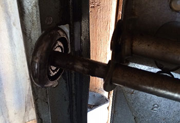 Old garage door roller heavily worn inside track of Coral Springs sectional door