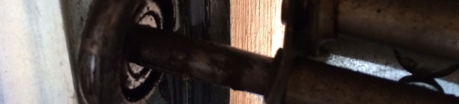 Old garage door roller heavily worn inside track of Coral Springs sectional door
